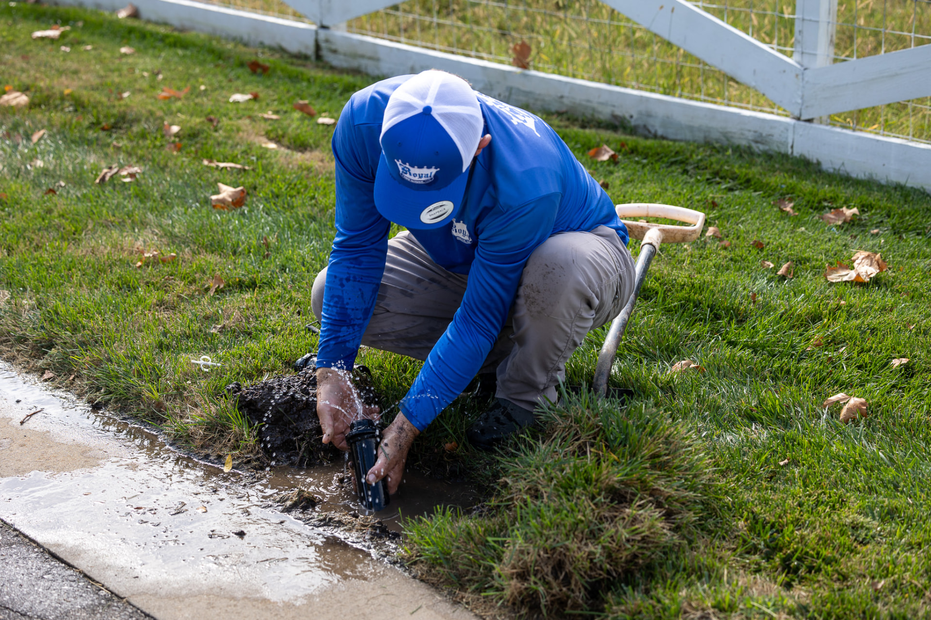 Royal technician flushing and adjusting a sprinkler head during a spring start-up